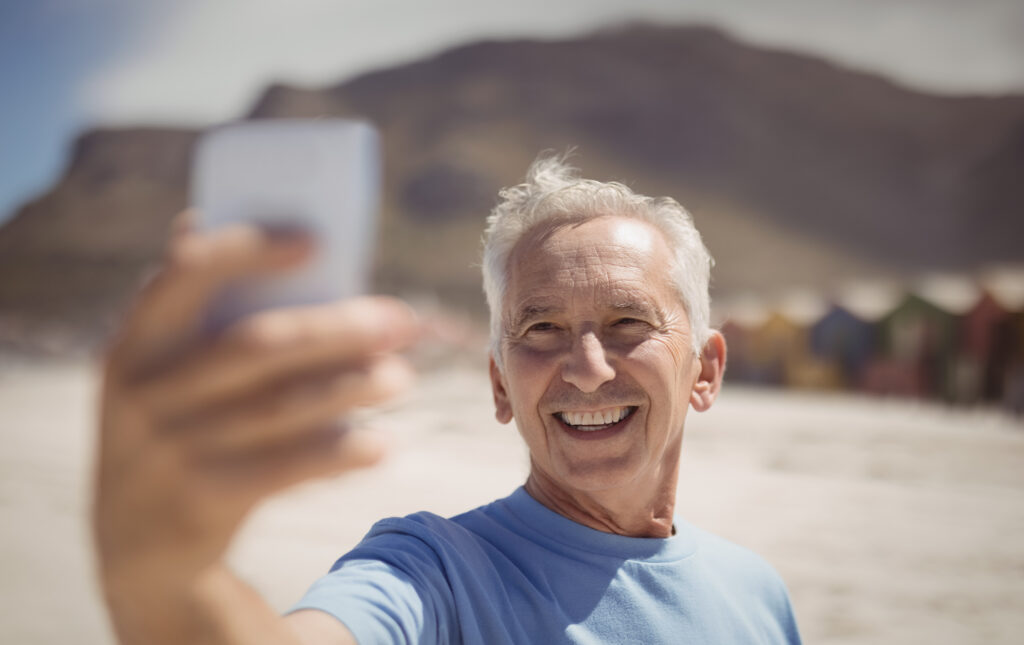 Happy senior man taking selfie on beach 2023 11 27 05 05 44 UTC